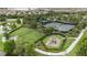 Aerial view of a community playground area featuring grassy areas and walking paths next to a lake at 11398 Juglans Dr, Odessa, FL 33556