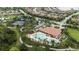 Aerial view showcases a community pool with tanning deck and the poolhouse with a beautiful terracotta roof at 11398 Juglans Dr, Odessa, FL 33556