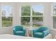 Comfortable sitting area in the main bedroom with beautiful views of nature through large windows at 11398 Juglans Dr, Odessa, FL 33556