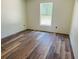 Bright bedroom with wood-look flooring and a window offering natural light at 11406 Labrador Duck Rd, Weeki Wachee, FL 34614