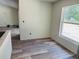 Living room featuring a window, luxury vinyl plank flooring, and neutral paint at 11406 Labrador Duck Rd, Weeki Wachee, FL 34614