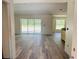 Spacious living room with sliding glass door and wood-look flooring offers natural light and backyard views at 11406 Labrador Duck Rd, Weeki Wachee, FL 34614