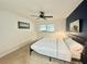 This bedroom features a ceiling fan, a painting on the wall and a comfortable bed at 11619 Boynton Ln, New Port Richey, FL 34654