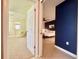 View from doorway of bedroom with deep blue accent wall and adjacent sitting room at 11619 Boynton Ln, New Port Richey, FL 34654