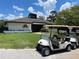 Exterior view of the community's golf clubhouse and golf carts with lush green landscaping at 11619 Boynton Ln, New Port Richey, FL 34654