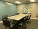 This conference room features a large central table, seating for eight, and modern abstract art at 11619 Boynton Ln, New Port Richey, FL 34654