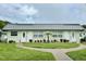 Charming exterior view of a well-maintained building with a manicured lawn and colorful flower beds at 11619 Boynton Ln, New Port Richey, FL 34654