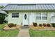 Close up front entrance featuring a well-maintained lawn with shrubs and a stone mulch bed at 11619 Boynton Ln, New Port Richey, FL 34654