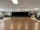 Hall with wood dance floor, stage, tables, chairs, tile floor, and stage with curtains at 11619 Boynton Ln, New Port Richey, FL 34654