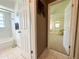 Hallway leads to the bathroom and a room with carpeted floors and bright natural light at 11619 Boynton Ln, New Port Richey, FL 34654