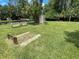 Enjoy outdoor games at the horseshoe pit featuring benches, lush green grass, and a storage shed at 11619 Boynton Ln, New Port Richey, FL 34654