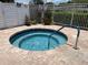 Inviting outdoor community hot tub with brick paver surround and manicured landscaping at 11619 Boynton Ln, New Port Richey, FL 34654