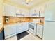 Well-lit kitchen featuring white cabinets, modern appliances, and ample counter space at 11619 Boynton Ln, New Port Richey, FL 34654