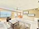 Bright living room featuring tile flooring, a ceiling fan, neutral paint and a view into the dining area at 11619 Boynton Ln, New Port Richey, FL 34654