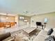 Bright living room area with open floor plan featuring tile flooring, ceiling fan, dining table and chairs at 11619 Boynton Ln, New Port Richey, FL 34654