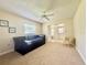 Living room includes a ceiling fan, neutral walls, carpet, and a full sized futon at 11619 Boynton Ln, New Port Richey, FL 34654