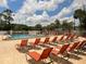A refreshing community pool is surrounded by lounge chairs and lush landscaping at 11619 Boynton Ln, New Port Richey, FL 34654