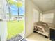 Charming sun room with an inviting view through an open door and palm trees and community at 11619 Boynton Ln, New Port Richey, FL 34654
