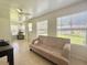 A sun-room features bright windows and a tile floor as well as a light colored futon at 11619 Boynton Ln, New Port Richey, FL 34654