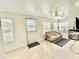 Cozy sunroom with multiple windows, neutral tones, and a comfortable couch at 11619 Boynton Ln, New Port Richey, FL 34654
