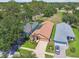 Aerial view of a well-maintained home with lush landscaping and a long driveway at 11752 Wheatfield Loop, Hudson, FL 34667