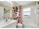 Cozy bathroom featuring a tub with shower, vanity, and decorative accents at 11752 Wheatfield Loop, Hudson, FL 34667