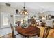 Dining room with hardwood floors, an overhead chandelier, and an adjacent living area at 11752 Wheatfield Loop, Hudson, FL 34667