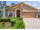 Charming single-story home with a manicured lawn, covered entry, and attached two-car garage at 11752 Wheatfield Loop, Hudson, FL 34667