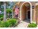 View of the house with decorative plants and an American flag flying near the front door at 11752 Wheatfield Loop, Hudson, FL 34667