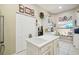 Kitchen with island, white cabinets, and view to the outdoor seating area at 11752 Wheatfield Loop, Hudson, FL 34667