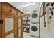 Efficient laundry area with stacked washer and dryer plus storage shelving at 11752 Wheatfield Loop, Hudson, FL 34667