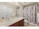 Bathroom with double sinks, tile flooring, and a shower with a patterned curtain at 12055 Colony Lakes Blvd, New Port Richey, FL 34654