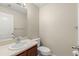 A clean bathroom featuring a toilet, sink, cabinet and towel rack with neutral wall and floor tiles at 12055 Colony Lakes Blvd, New Port Richey, FL 34654