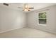 Bedroom featuring a ceiling fan and a window with views of green trees at 12055 Colony Lakes Blvd, New Port Richey, FL 34654