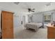 Serene bedroom with light gray walls, a ceiling fan, a bed, and wooden furniture at 12055 Colony Lakes Blvd, New Port Richey, FL 34654