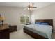 Bedroom featuring a ceiling fan, a window, and a sizable bed with blue pillows at 12055 Colony Lakes Blvd, New Port Richey, FL 34654
