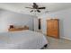 Calm bedroom featuring gray walls, ceiling fan, carpeted floors, and natural wood furniture at 12055 Colony Lakes Blvd, New Port Richey, FL 34654