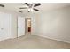 Neutral bedroom featuring a ceiling fan, carpet flooring, and access to an ensuite bathroom at 12055 Colony Lakes Blvd, New Port Richey, FL 34654