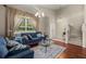 Bright living room with hardwood floors, comfortable sofas, and large windows with curtains at 12055 Colony Lakes Blvd, New Port Richey, FL 34654