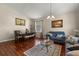 Cozy living room featuring hardwood floors, comfortable seating, and ample natural light at 12055 Colony Lakes Blvd, New Port Richey, FL 34654