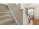 Carpeted staircase with white trim leads to a dining area with modern decor and ample natural light at 12055 Colony Lakes Blvd, New Port Richey, FL 34654