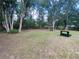 Expansive backyard featuring mature trees, green grass, and a peaceful, serene environment at 12090 Stoneville Ct, Spring Hill, FL 34609