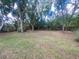 Large backyard with mature trees, grassy areas, and a peaceful setting at 12090 Stoneville Ct, Spring Hill, FL 34609