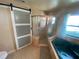 Bathroom with tiled flooring, garden tub, step-in shower with sliding barn door at 12090 Stoneville Ct, Spring Hill, FL 34609