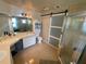 Large bathroom featuring double vanity, large mirror, step-in shower with a sliding barn door at 12090 Stoneville Ct, Spring Hill, FL 34609