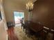 Dining area with chandelier, sliding glass doors to the patio, and views of the pool at 12090 Stoneville Ct, Spring Hill, FL 34609