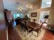 Open dining space with chandelier, wood floors and views of the living room and backyard at 12090 Stoneville Ct, Spring Hill, FL 34609