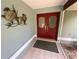 Inviting entryway with red double doors and decorative turtle wall art, creating a warm, coastal ambiance at 12090 Stoneville Ct, Spring Hill, FL 34609