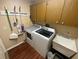 Laundry room featuring a modern washer and dryer, utility sink, and overhead cabinets for storage at 12090 Stoneville Ct, Spring Hill, FL 34609