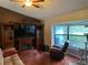 Comfortable living room with fireplace, large windows, and hardwood floors at 12090 Stoneville Ct, Spring Hill, FL 34609